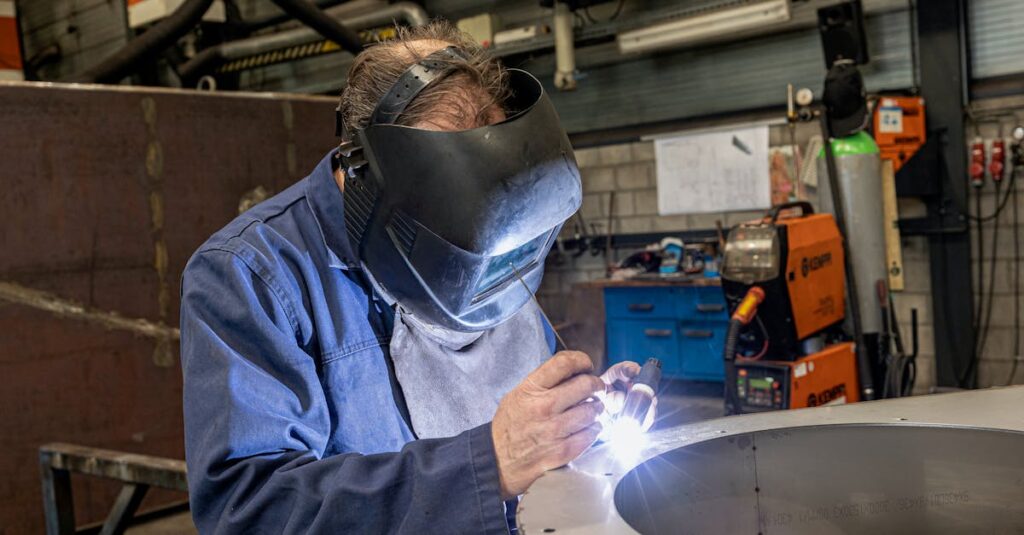 A skilled welder working in a modern workshop with advanced equipment and safety gear.