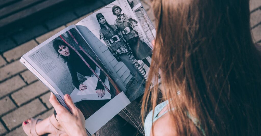 Outdoor shot of a woman reading a fashion magazine with a focus on style and fashion details.