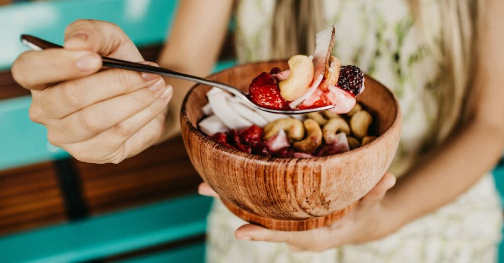Healthy acai smoothie bowl with fresh berries and nuts held in a wooden bowl.