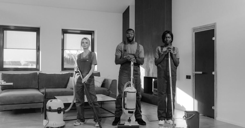 A team of three professional cleaners in uniforms with equipment ready for housekeeping.