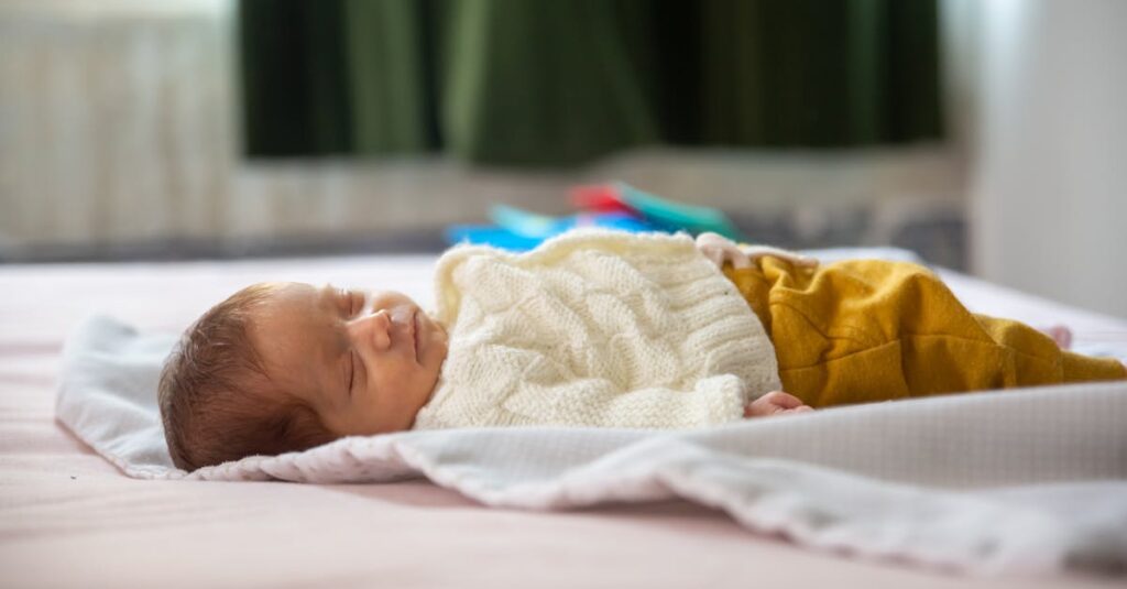 Adorable newborn baby sleeping peacefully on a bed indoors.