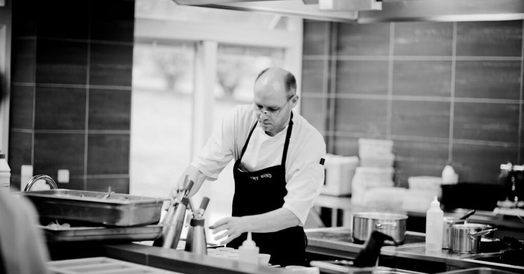 Chef in a restaurant kitchen carefully preparing dishes with attention to detail.