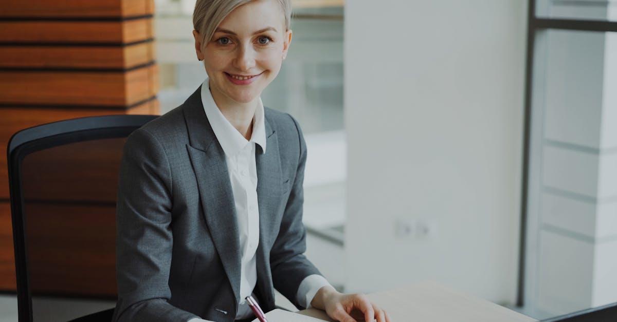 Professional businesswoman smiling at desk in modern office environment.