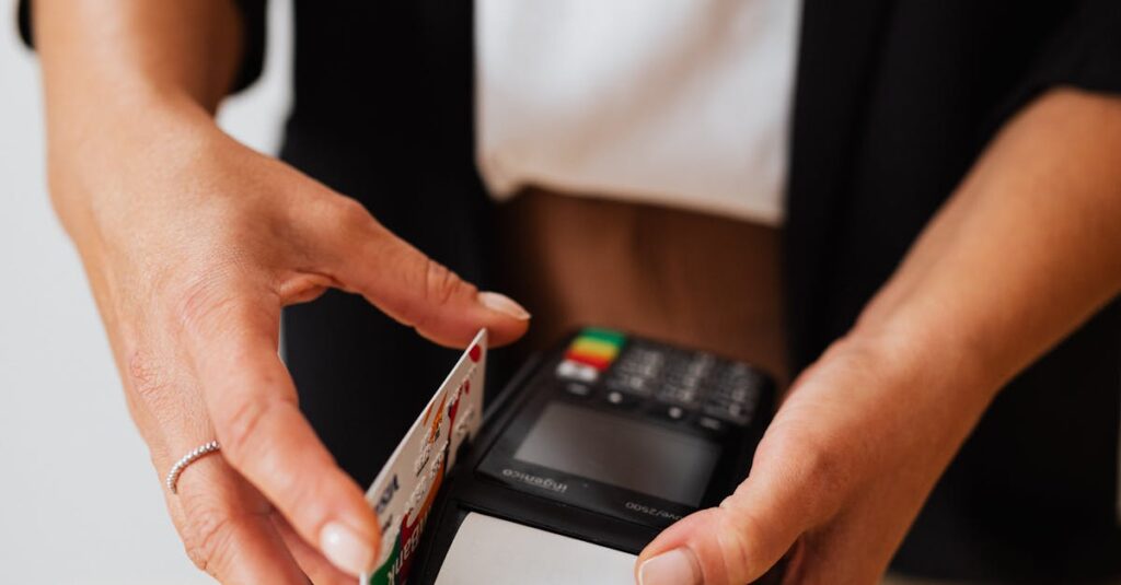 Close-up of hands using a credit card on a POS machine, illustrating cashless transactions.