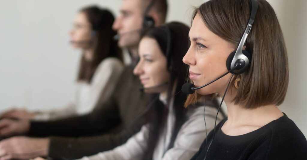 Customer support team working with headsets in a modern office setting.